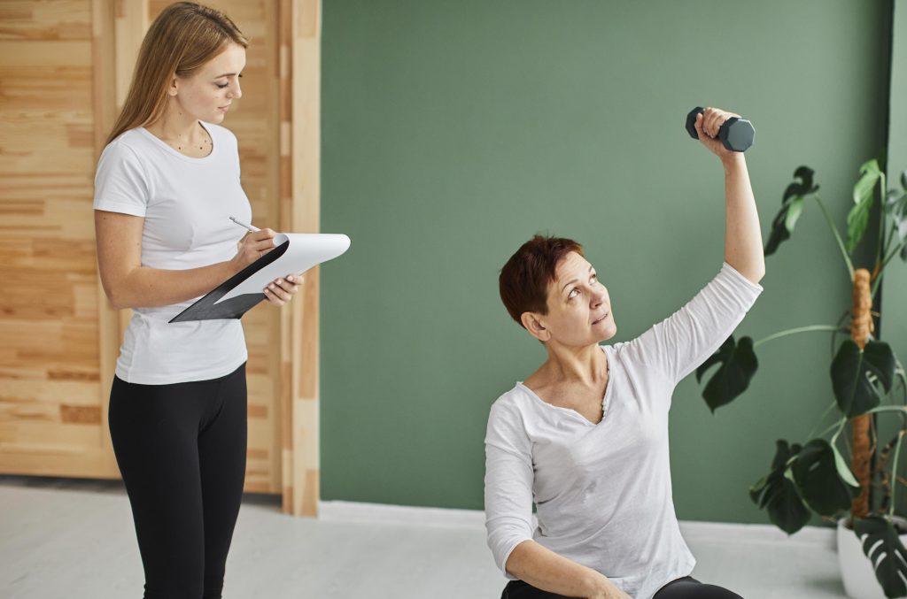 female physiotherapist professional helping a white elite women for arthritis and diabetes cure through personalized focused and detailed physiotherapy session.