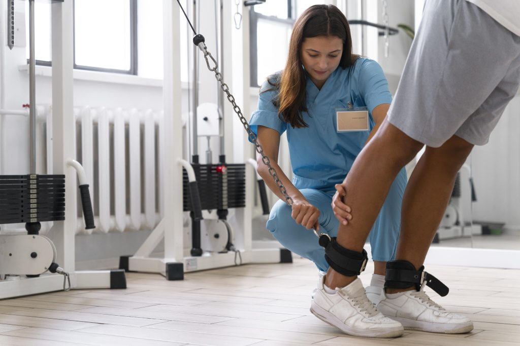 A young female physiotherapy professional helping with foot exercise of the patient inside family gym-the treatment will help to manage Arthritis related chronic pain of the patient.