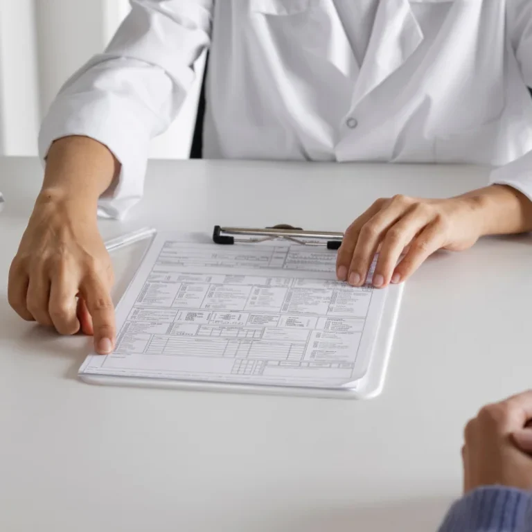 Doctor checking patient’s record sheet during Chronic Disease Management